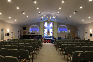 An empty church worship space with a nativity scene at the altar and a Christmas tree to the right.